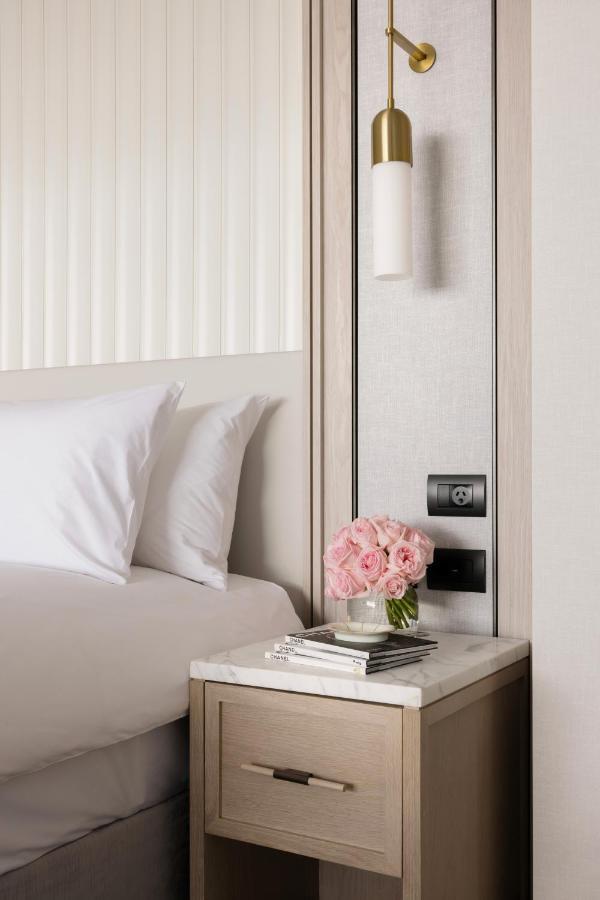 The Langham, Gold Coast And Jewel Residences Eksteriør bilde A bedside table with a lamp, a telephone and a vase of flowers